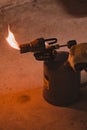 Gasoline blowtorch with a burning fire, the use of a blowtorch in construction.