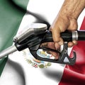 Gasoline consumption concept - Hand holding hose against flag of Mexico Royalty Free Stock Photo