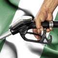 Gasoline consumption concept - Hand holding hose against flag of Nigeria Royalty Free Stock Photo