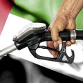 Gasoline consumption concept - Hand holding hose against flag of United Arab Emirates Royalty Free Stock Photo