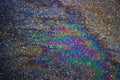 Gasoline flows on the asphalt surface. Iridescent stains of gasoline. Royalty Free Stock Photo