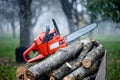 Gasoline powered professional chainsaw on pile of cut wood Royalty Free Stock Photo