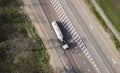 Gasoline truck Oil trailer on highway driving along the road. Tank vehicle at work aerial view above