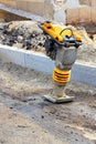 Gasoline vibratory rammer on the background of a construction site on a sunny day