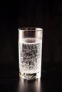 Gassed water in a glass on a black table and black background Royalty Free Stock Photo