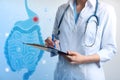 Gastroenterologist holding clipboard and virtual image of intestine on light background, closeup Royalty Free Stock Photo