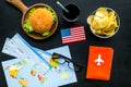 Gastronomical tourism with american flag, passport, tickets, map, burgers, chips, drink on black background top view Royalty Free Stock Photo