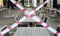 Gastronomy lockdown due to corona epidemic, closed restaurant terrace,chairs, tables and barrier tape, symbolic