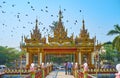 The gate of Buddhist monastery with flying pigeons, Yangon, Myanmar Royalty Free Stock Photo