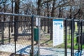 Gate entrance public dog park secured with galvanized vinyl-coated chain link fences, steel posts panels, concrete floor at rest