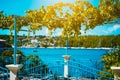 Gate and fence of traditional Greek house with vine growing on terrace. Picturesque bay behind the blue fance Royalty Free Stock Photo
