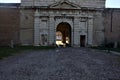 Gate of a fortification on a cobbled square of an italian town at sunset Royalty Free Stock Photo