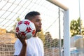 gate keeper throwing foot ball looking away at dusk in soccer field