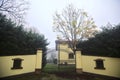 Gate of a mansion with hedges on a foggy day in the italian countryside