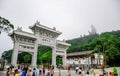 Gate to the Po Lin Monastery with Tian Tan Buddha statue up on the hill in Ngong Ping Village, Lantau Islan Royalty Free Stock Photo