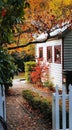 Gate to a small wooden cottage with autumn coloured trees