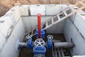 Gate valves in valve pit of the underground piping networks. Laying water system pipeline at construction site. Water supply Royalty Free Stock Photo