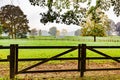 Gate of a wooden fence in the countryside with trees and some fog in the background Royalty Free Stock Photo