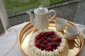 Gateau with strawberry and cream is waiting to be served together with a cup of strong coffee