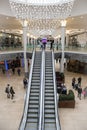 Interior inside of modern shopping centre mall with escalators and luxury chandelier Royalty Free Stock Photo