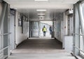 People including man in hi viz walking through a modern light tunner walkway