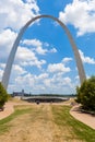 The Gateway Arch in St. Louis, Missouri with people walking around and sky with clouds in the background Royalty Free Stock Photo