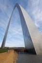 Gateway Arch under a blue sky with white clouds, bridge over the Mississippi River in the background Royalty Free Stock Photo