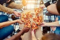 Gather around for a slice of the best. a group of friends eating pizza while having a picnic.