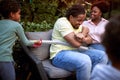 Gathered african family. Son playing and teasing father with plastic sword