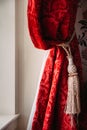 Gathered Red Velvet Curtains With Gold Tassel In A Rustic Old En