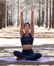 Gathering good energy from the universe. an attractive young woman sitting alone on a yoga mat outdoors and meditating.