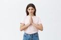 Gathering wisdom from meditation. Portrait of calm focused good-looking european woman practicing yoga holding hands in