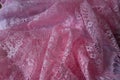 Gauzy pink lacy fabric in folds