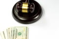 A gavel or auction hammer and dollar bills