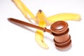 Gavel and Banana Peel on Gradated Background Royalty Free Stock Photo