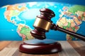 A gavel clutched against a globe backdrop, symbolizing the rule of law