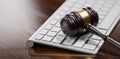 Gavel at the computer keyboard: Legal and law concept. Wooden hammer of justice and order Royalty Free Stock Photo