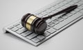 Gavel at the computer keyboard: Legal and law concept. Wooden hammer of justice and order Royalty Free Stock Photo