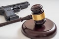 Gavel in front of a pistol. Gun laws and legislation concept