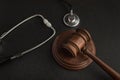 Gavel hammer of judge and stethoscop on black background. Sentence on medical negligence