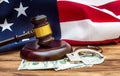 Gavel, handcuffs, money and american flag on wooden table. American law