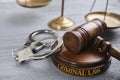 Gavel, handcuffs and scales of justice on wooden table. Criminal law concept