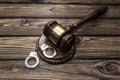 Gavel of the judge, handcuffs for the detention of criminals against the background of a wooden table. Royalty Free Stock Photo