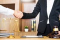 Gavel Justice hammer on wooden table with judge and client shaking hands after adviced in background at courtroom, lawyer service Royalty Free Stock Photo