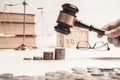 Gavel of lawyer with education book, house model and coin. Royalty Free Stock Photo