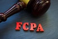 Gavel and letters FCPA Foreign Corrupt Practices Act on a wooden surface.