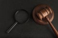 Gavel with magnifying glass on black background. Forensic investigation. Collection of evidence. Jurisprudence concept