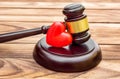 Gavel with red heart on wooden table. Close up Royalty Free Stock Photo