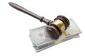 Gavel Resting on Stacks of Thousands of Dollars Isolated on a White Background