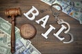 Gavel, Sign BAIL, Handcuffs And Dollar Cash On Wood Background